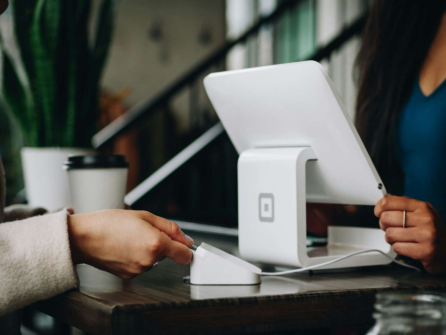 A local shop owner taking a card payment at the counter of their café